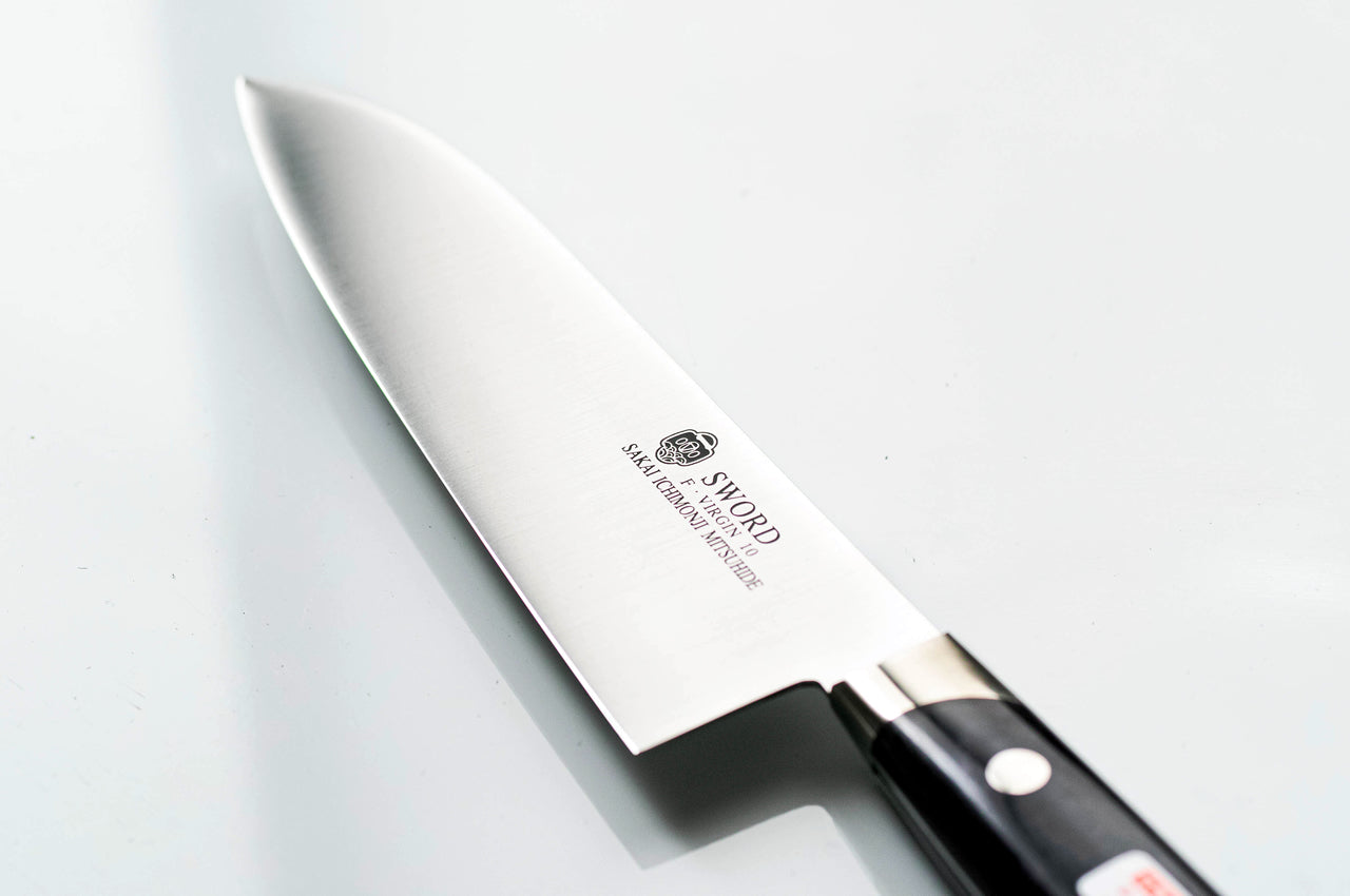 白背景に置かれた堺一文字光秀の三徳包丁。錆びにくく鋭い切れ味のVG10ステンレス鋼の刃と、上品なパープル色ハンドルのアップ写真。