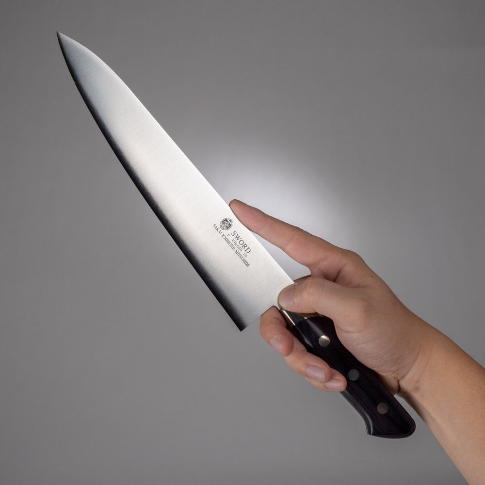 手に持った堺一文字光秀の洋包丁「SWORD」シリーズ、光沢のある刃と黒い柄が特徴的なプロ仕様の牛刀